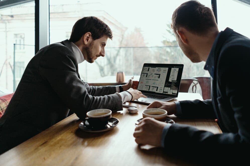 Two business professionals reviewing mobile app strategy during a working lunch meeting
